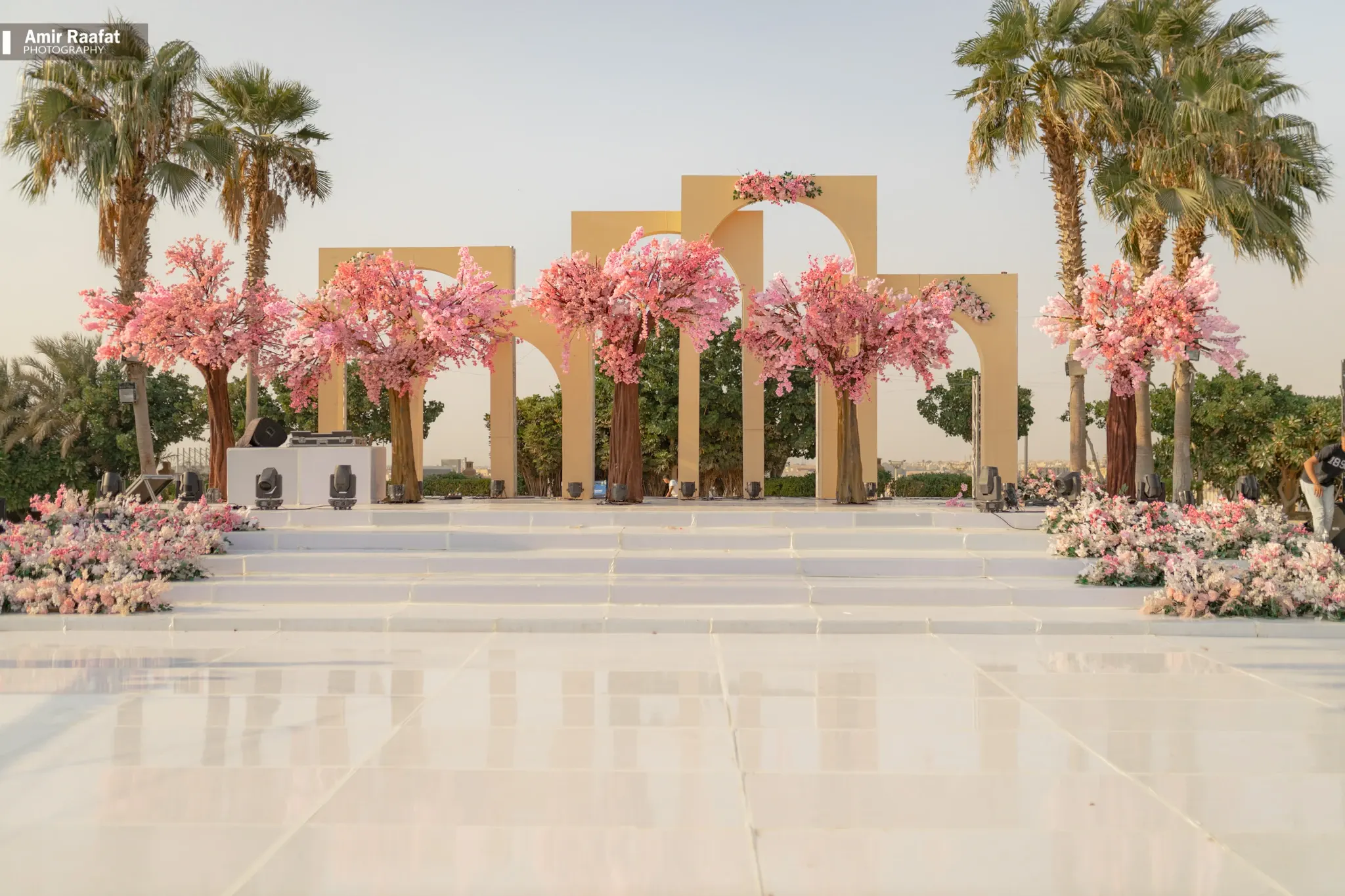 A wedding setting with pink flowers and palm trees